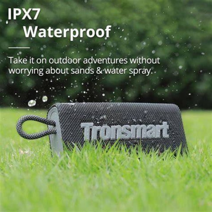 Tronsmart Trip portable Bluetooth speaker dangling from a finger